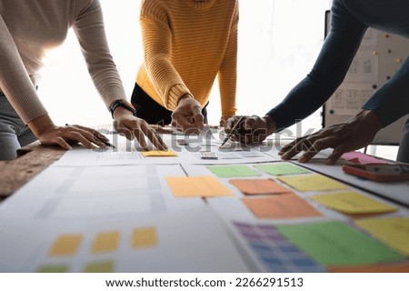 Close up ux developer and ui designer brainstorming about mobile app interface wireframe design on table with customer brief and color code at modern office.Creative digital development agency.panning Royalty-Free Stock Photo #2266291513