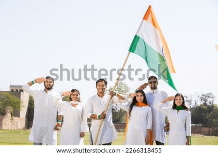 Group of happy young people wearing traditional white dress holding indian flag celebrating Independence day or Republic day. Royalty-Free Stock Photo #2266318455