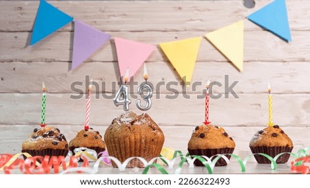 Festive birthday cakes with candles. Birthday background with numbers  43. Anniversary cards on a wooden background.