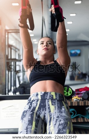 Young beautiful sporty woman is doing exercises in a fitness room. Gym workout