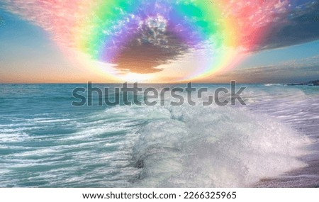 Amazing rainbow over the strong sea wave at amazing sunset