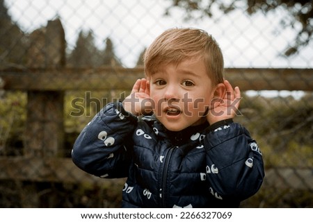 Cute little three years boy with hearing problem. Funny boy listens carefully. Family communication with kid. Hear parent. Interesting education news. Royalty-Free Stock Photo #2266327069