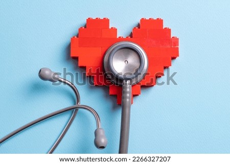 stethoscope standing on red heart on blue background