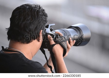 backside view of a photographer holding camera