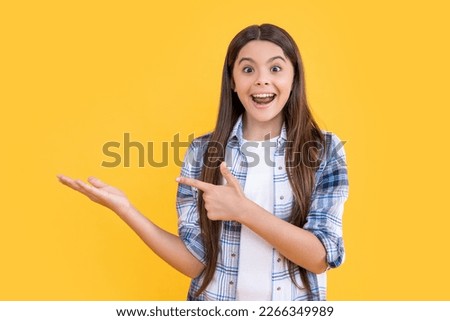 photo of surprised teen girl with long hair wearing checkered shirt. teen girl