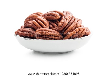 Peeled pecan nuts in bowl isolated on the white background.