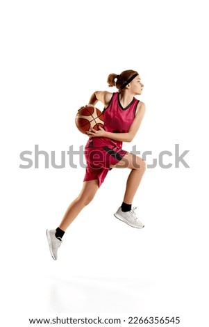 Dynamic portrait of young, teen girl, basketball player in motion, training isolated over white studio background. Concept of sportive lifestyle, active hobby, health, endurance, competition