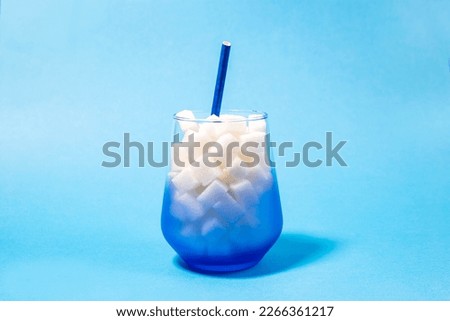 Glass with rafined sugar cubes on pink background, copy space, drinks with a lot of sugar dangerous for health, diabetes concept  Royalty-Free Stock Photo #2266361217