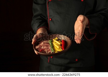 The chef presents an appetizer on a serving plate with sliced ham and cheese. Dark free space for recipe or menu.