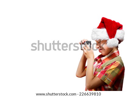 Funny little child dressed as Santa taking photo with camera smiling. Christmas concept. 