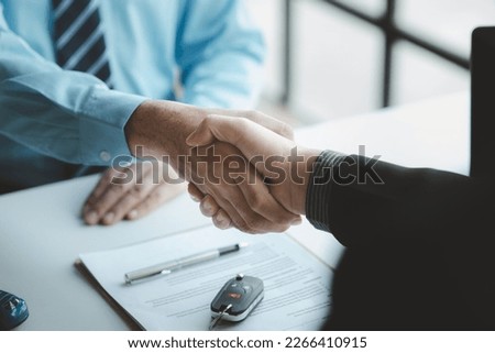 A car salesman is explaining the purchase details and details in the car purchase contract before signing acceptance of the terms, the car sales contract through an agent. Car trading concept. Royalty-Free Stock Photo #2266410915