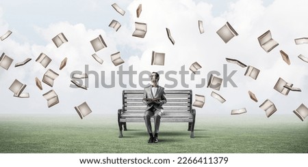 Funny man in red glasses and suit sitting on bench and reading book