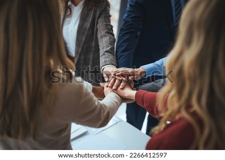 Large sea of hands. Group of business workers standing with hands together at the office. Symbol of teamwork, cooperation and unity. Stack of hands of men and woman.