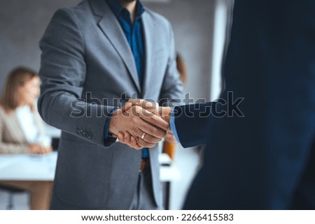 Good deal. Close-up of two business people shaking hands while sitting at the working place. Bussiness,working, success concept. Portrait of manager handshake with new employee. Royalty-Free Stock Photo #2266415583