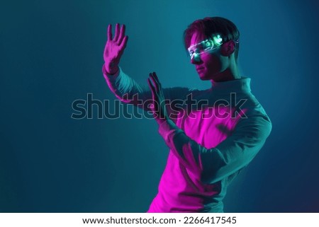 man has virtual experience with hands try to touch the virtual simulation he see on his eyes caused by light of futuristic glasses Royalty-Free Stock Photo #2266417545