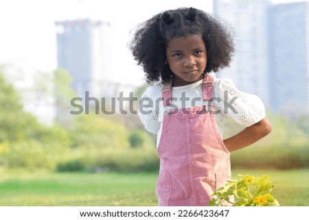 Child girl hides something in her hand behind her back, and show funny face Royalty-Free Stock Photo #2266423647