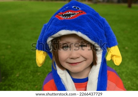 Purim, Halloween. Cute boy in a funny hat with ears. The smile of a child, a festive mood. A boy in a carnival costume. Portrait of a child in a festive headdress.