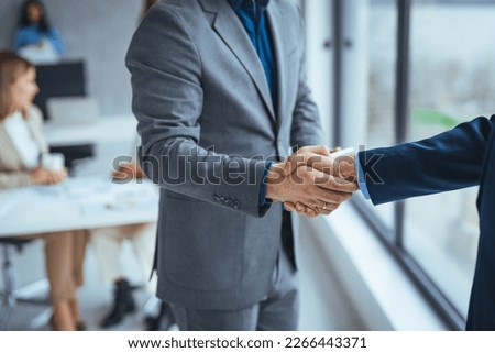 Good deal. Close-up of two business people shaking hands while sitting at the working place. Bussiness,working, success concept. Portrait of manager handshake with new employee.