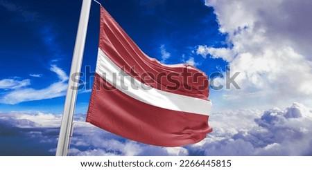Latvia national flag cloth fabric waving on beautiful blue sky.