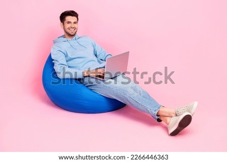 Photo of positive man professional it specialist sit comfy bag work from home empty space isolated on pink color background