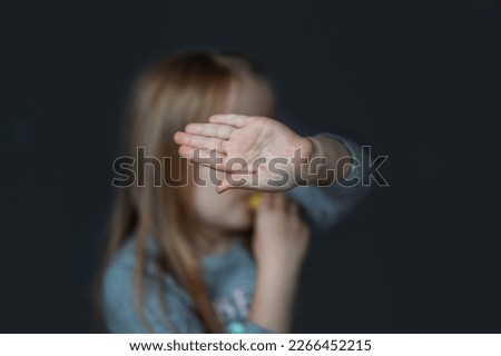 The girl covers her face with her hand. Contempt. Rejection. The girl doesn't want her picture taken.