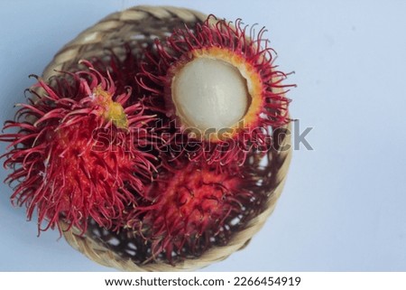 rambutan fruit in a small basket on a white background