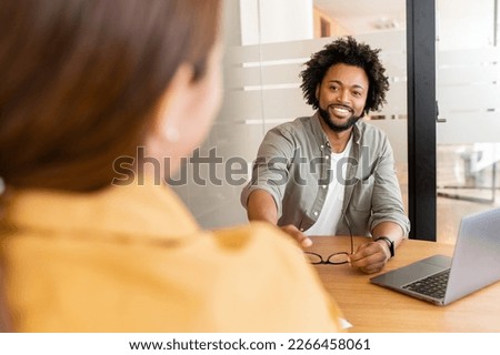 Two young happy colleague using laptop in office and communicating while working together in coworking space, sharing new ideas, discussing project strategy Royalty-Free Stock Photo #2266458061