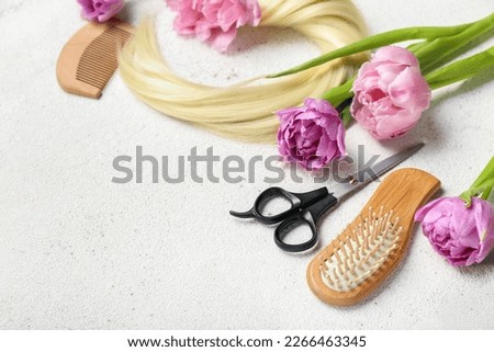 Hairdresser's tools with tulips on white background, closeup. Hello spring
