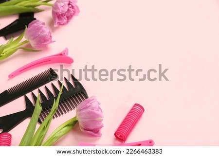 Hairdresser's tools with tulips on pink background, closeup. Hello spring