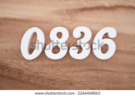 White number 0836 on a brown and light brown wooden background.