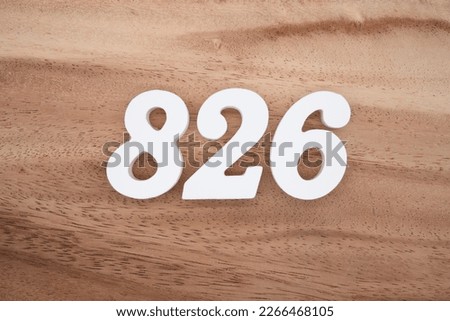 White number 826 on a brown and light brown wooden background.
