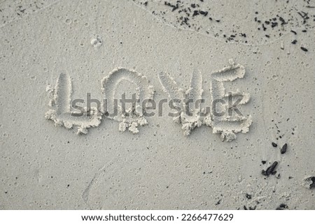 The word LOVE written on the sand at a beach