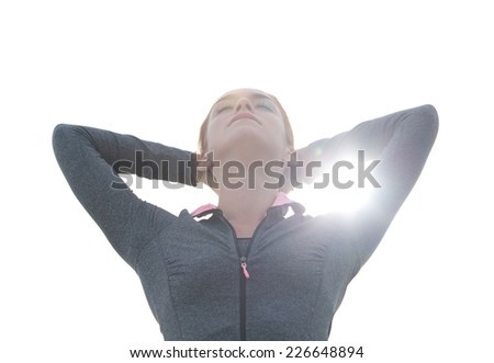 Close up portrait of a beautiful young woman with hands behind head