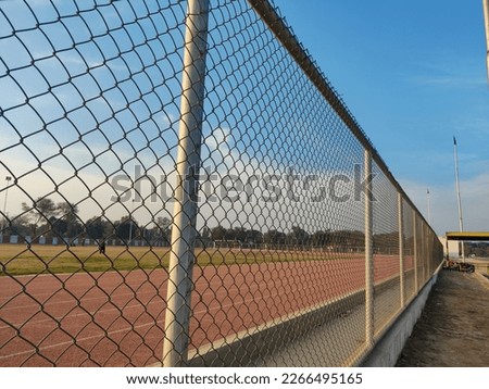 A fence in a football stadium and a blue sky