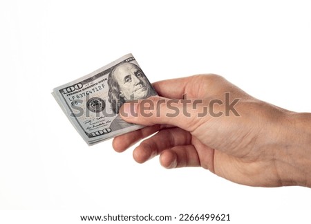 Man hand giving roll 100 dollar bills isolated on white background. One hundred us dollars Royalty-Free Stock Photo #2266499621