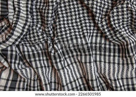 Background texture, pattern. Scarf wool like Yasser Arafat. The Palestinian keffiyeh is a gender-neutral checkered black and white scarf that is usually worn around the neck or head. Royalty-Free Stock Photo #2266501985
