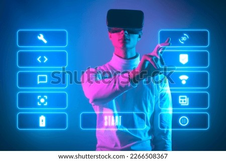 man with vr glasses is in virtual life and look up to virtual dashboard with options and icons to chose from make decision and start to play virtual game in augmented reality   Royalty-Free Stock Photo #2266508367