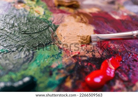 Palette with oil paints.Drawing hobby.Drawing school.Free time.Master class.Artist.A layer of paint.Mixing colors.Palette.Different colors.Close up.Wallpaper.Drawing with a brush.Oil paints.Learning.