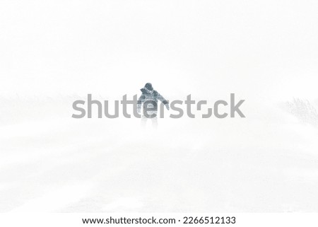 Snowstorm in the city winter is cold a teenager is walking along the road he is blown away by the wind Royalty-Free Stock Photo #2266512133