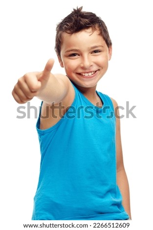 Well done. Portrait of a little boy with his thumbs up isolated on studio background. Young casual child showing okay gesture with his hand. One happy excited male kid doing a good luck hand sign.