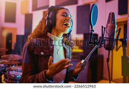 Tablet, music and woman singing in a studio for radio, song production and rehearsal. Creative, voice and a singer making a record, track or recording a musical sound as a professional artist Royalty-Free Stock Photo #2266512963