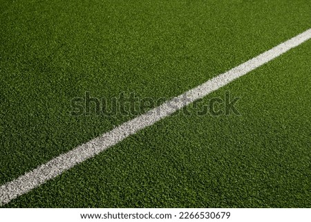 Sports field with green synthetic grass with a white and yellow line. Football, rugby, soccer, baseball concept Royalty-Free Stock Photo #2266530679