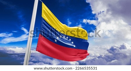 Venezuela national flag cloth fabric waving on beautiful blue sky.