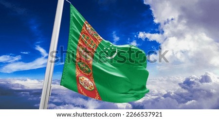 Turkmenistan national flag cloth fabric waving on beautiful blue sky.