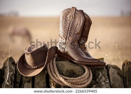 Country music festival live concert with cowboy hat and boots by ranch stables Royalty-Free Stock Photo #2266539405