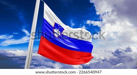 Slovenia national flag cloth fabric waving on beautiful blue sky.