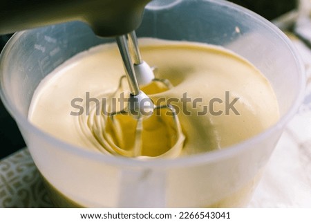Mixer.Whipping dough.Liquid dough.Kitchen appliances.Cooking at home.Hobby.Cooking.Dough making.Whipping cream.Good mixer. Cooking a cake.Home cooking.Recipe.Kitchen device.mixing.whisk.Ingredients. Royalty-Free Stock Photo #2266543041