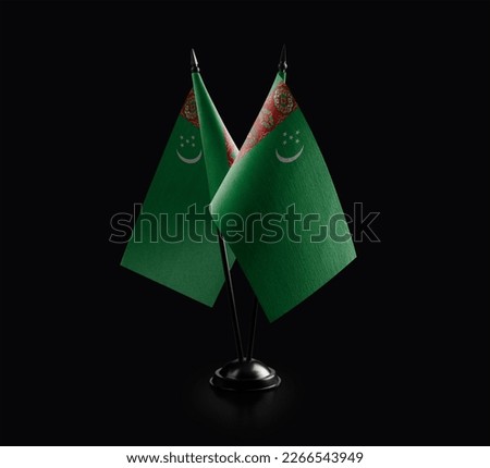Small national flags of the Turkmenistan on a black background.