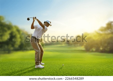Asian man golfer driver swing before hitting golf ball down the fairway. Royalty-Free Stock Photo #2266548289