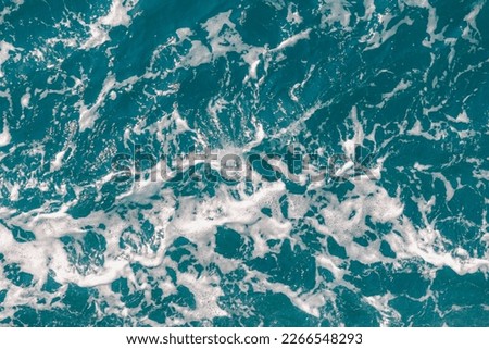 Top view from the ferry ship with sea wave with white foam or bubble in wavy or spiral pattern, Stop motion of water splashing during the boat is sailing with copy space, Nature texture background.
